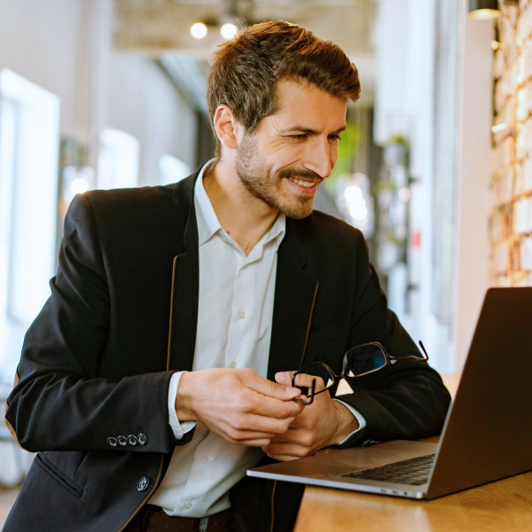 A Chief Executive Officer smiling holding glasses.