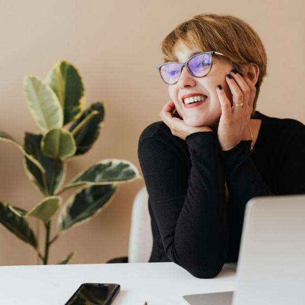 A Chief Executive Officer smiling at her desk.