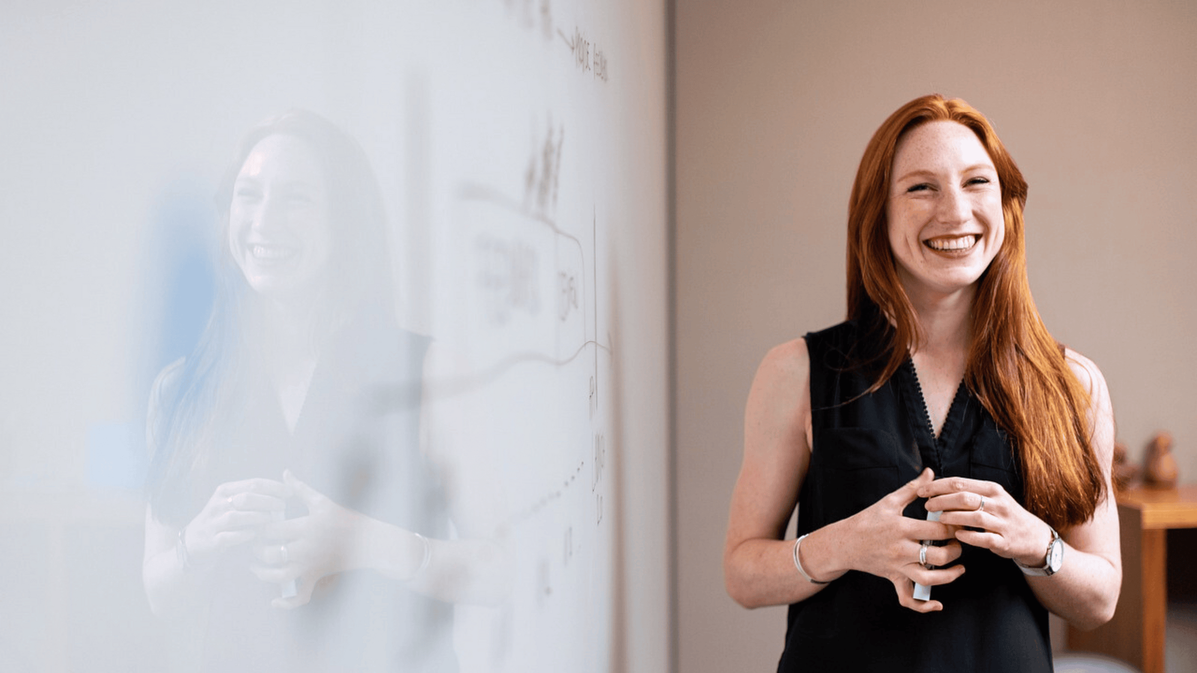 A woman, smiling, giving a simple yet effective presentation.